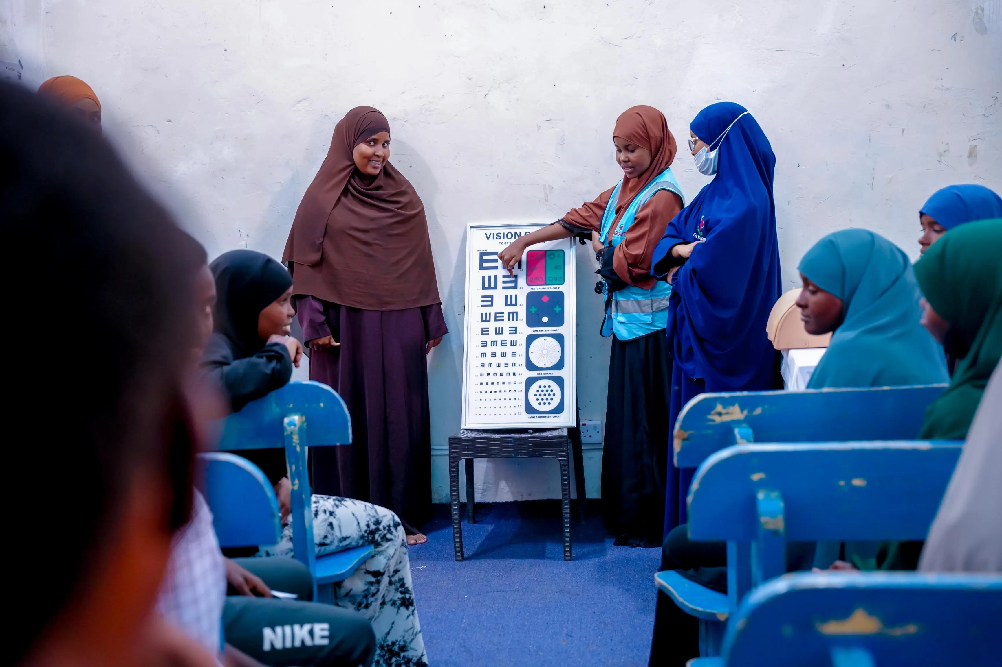 A healthcare worker presenting an eye chart during the community health and awareness event